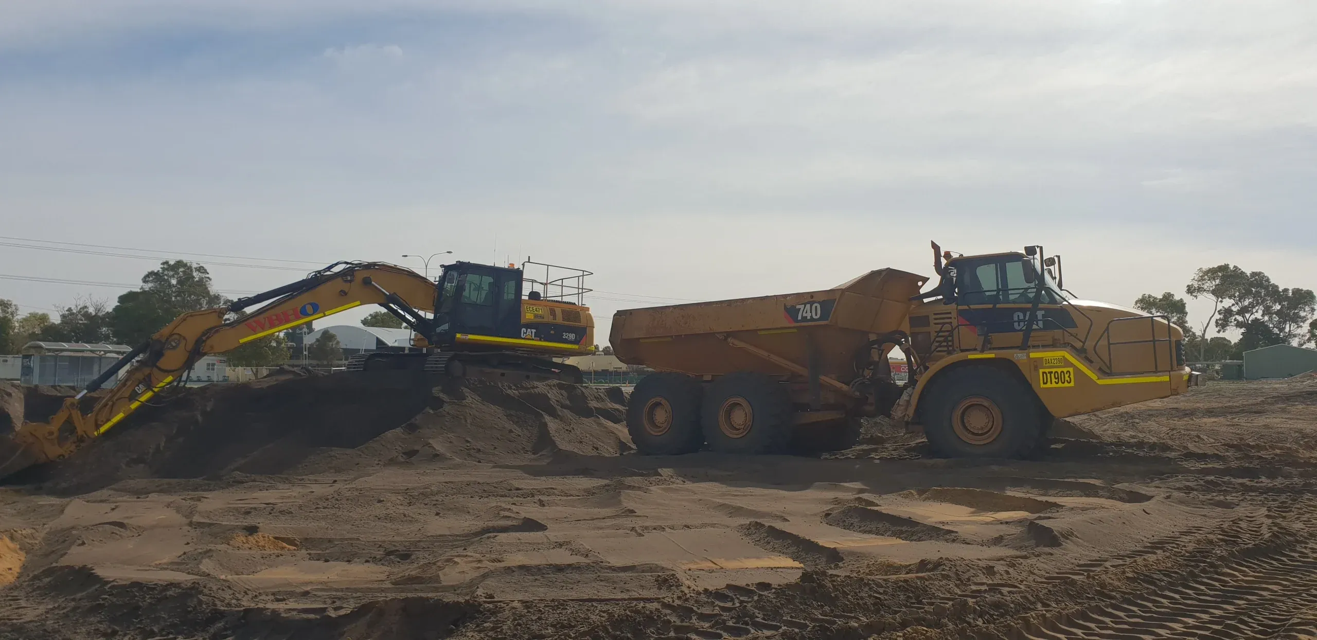 A yellow excavator working red earth