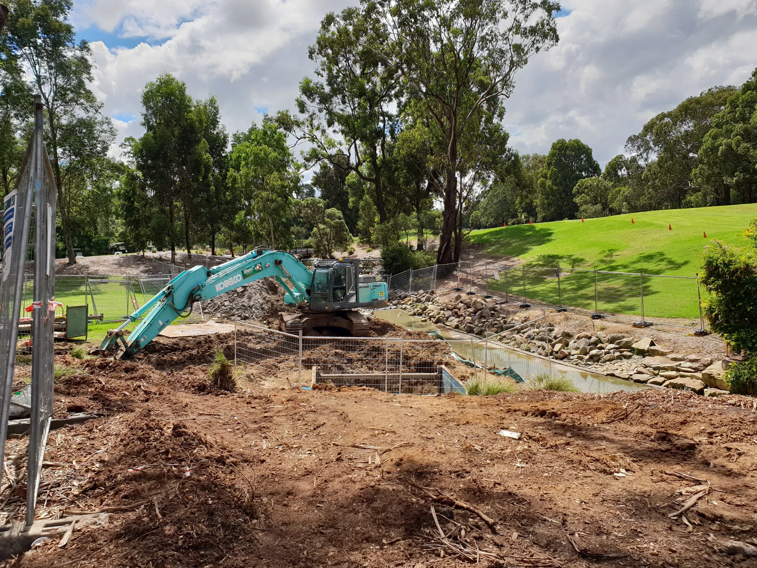 An excavator loading an articulated dumper on open ground
